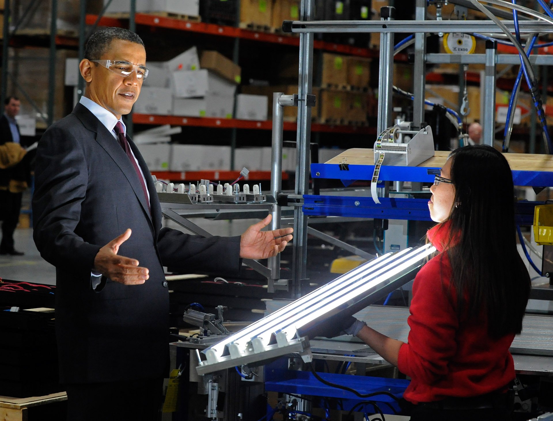 President Barack Obama beholds an Orion Energy Systems' high-intensity modular fluorescent light held by Marisol DeBaushe of Orion during Obama's visit to Manitowoc on Wednesday. Obama also visited Skana Aluminum Co. and Tower Tech Systems.