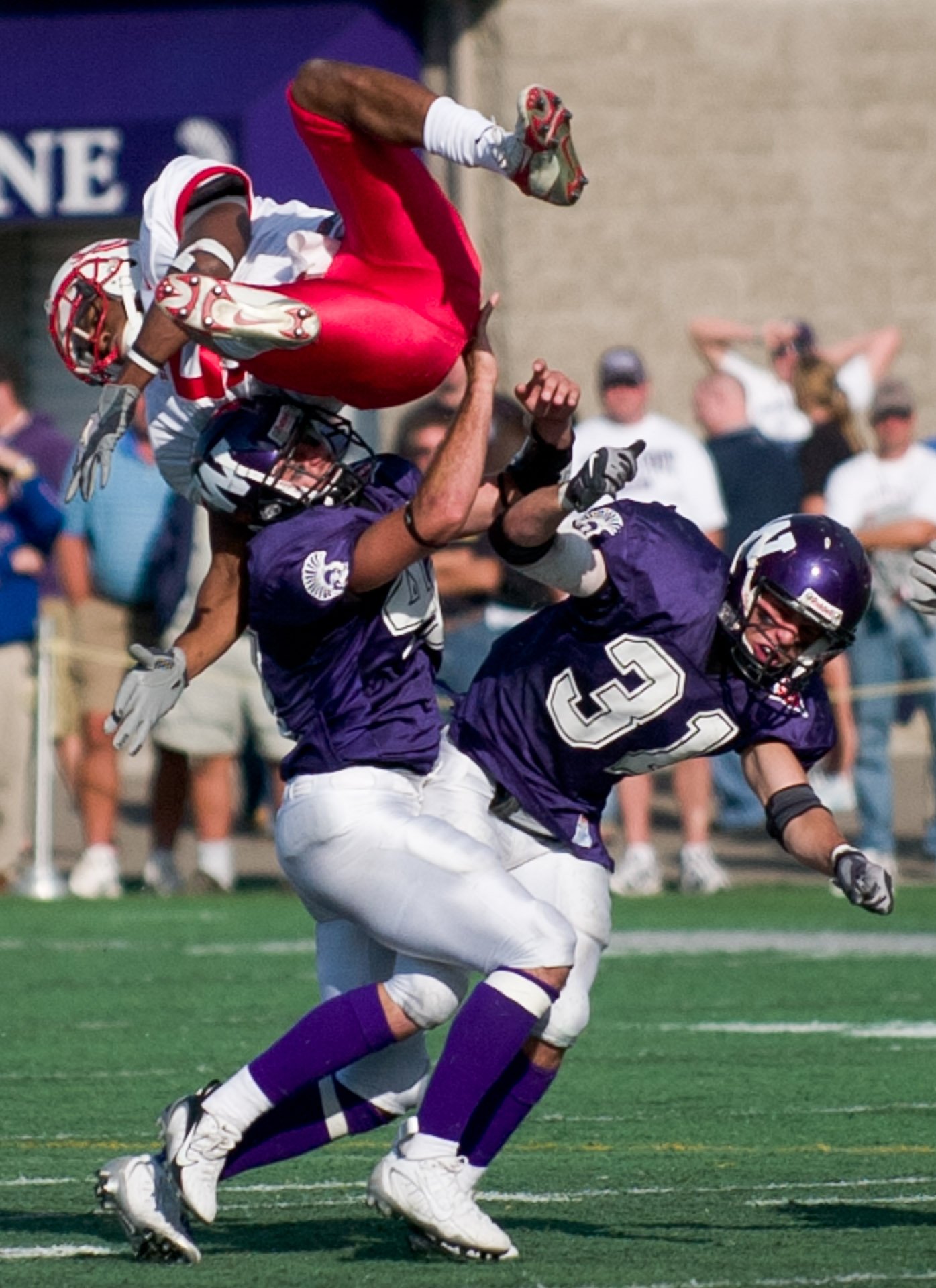 Football player throwing another football player over his head.